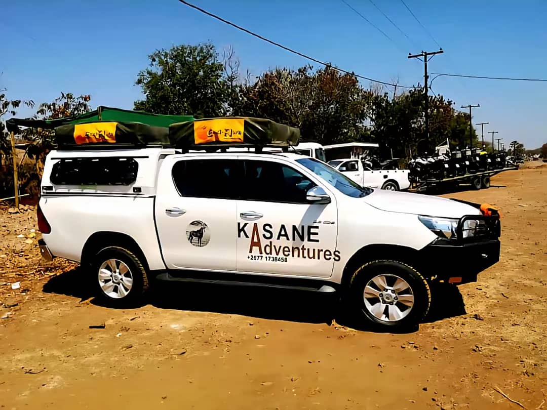 White rental pickup with rooftop camping equipment